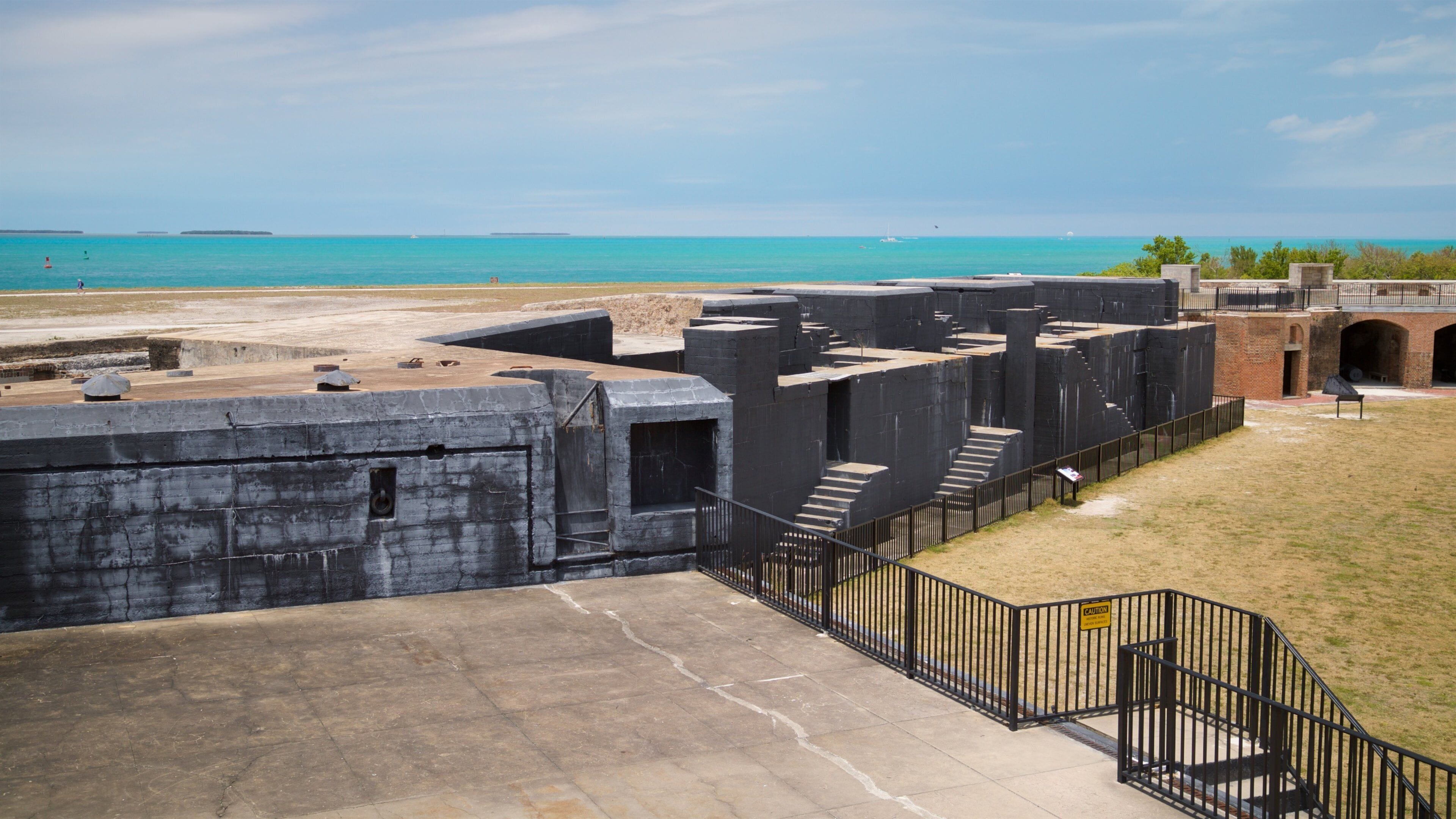 A coastal fortification with a staircase leading to a higher platform, overlooking the sea.