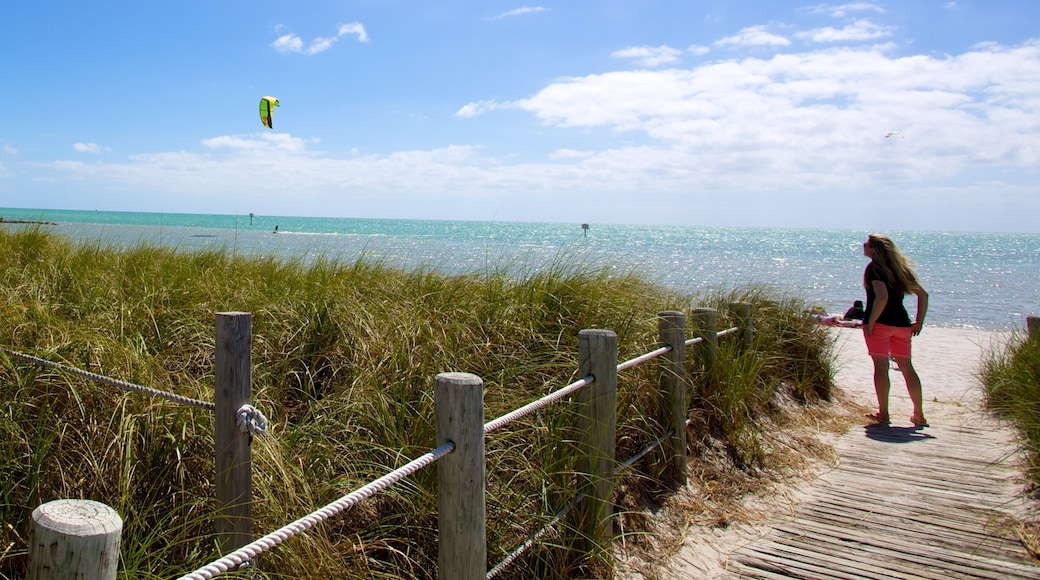Smathers Beach som inkluderar en bro och en sandstrand såväl som en kvinna