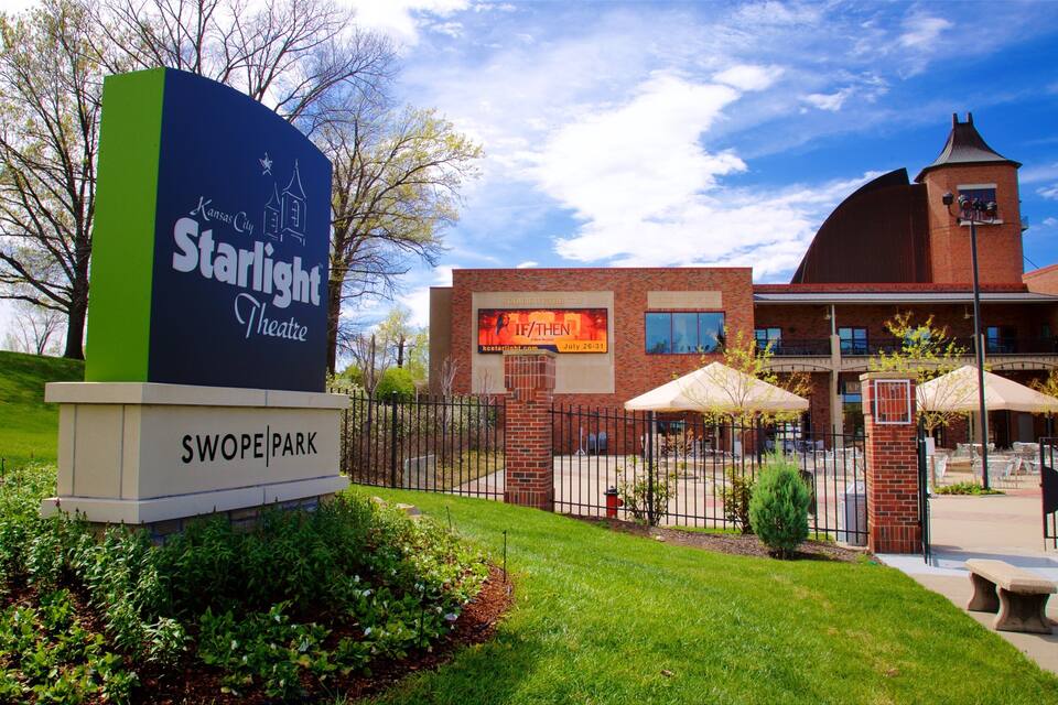 A sign for the Starlight Theatre in front of a brick building with a tower.