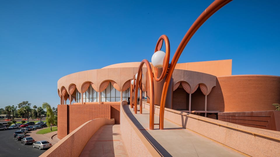 A modern building with a curved facade and large windows, featuring a unique series of arches and a prominent spiral structure.