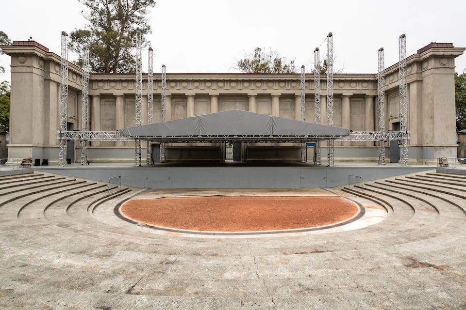 Un anfiteatro al aire libre con escenario y asientos.