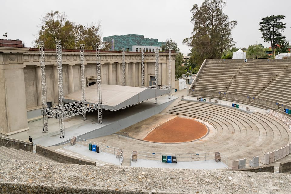 Un anfiteatro al aire libre con asientos escalonados y un escenario.