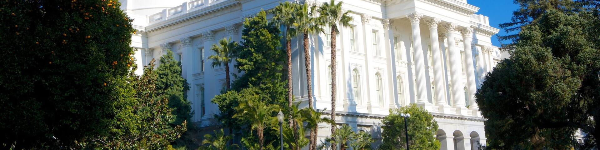 A large white building with a dome and columns, surrounded by trees.