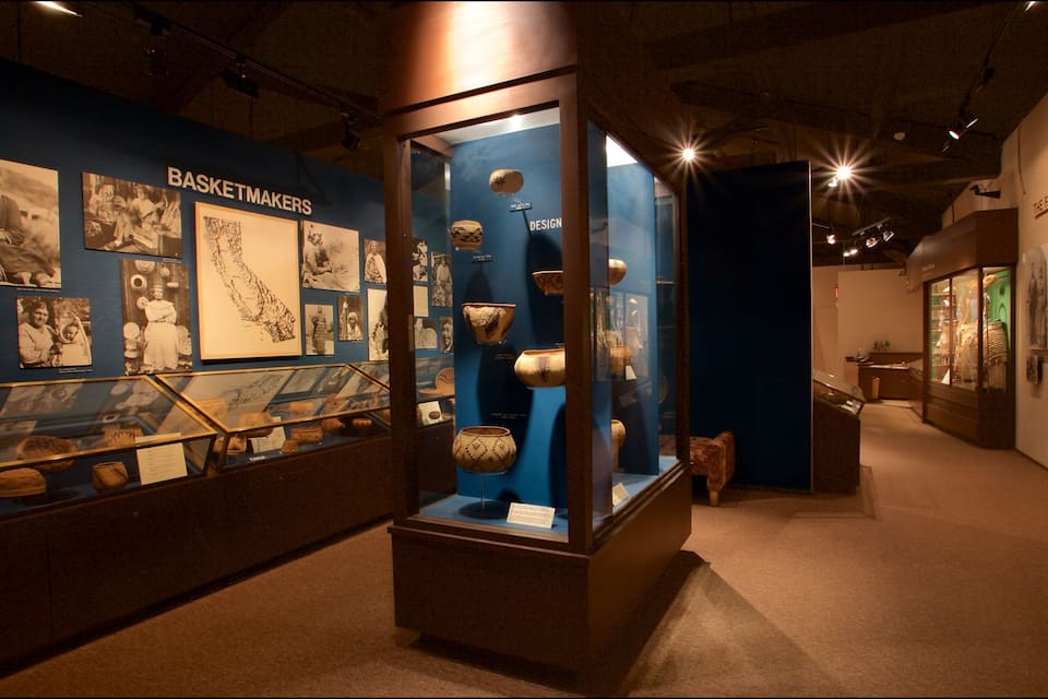 A museum exhibit with baskets and pottery.