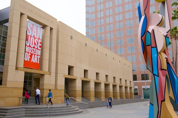 Le bâtiment du musée d’art de San José, avec une grande banderole rouge et une sculpture colorée à proximité.