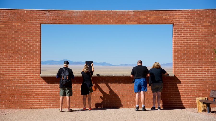 Meteor Crater which includes desert views and tranquil scenes as well as a small group of people