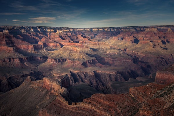 Un vaste canyon aux formations rocheuses stratifiées, sous un ciel dégagé.