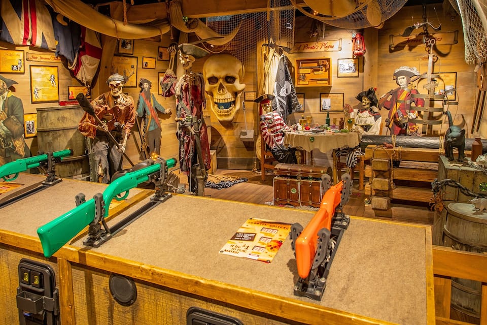 A pirate-themed exhibit with skeletons, pirate costumes, and maritime artifacts.