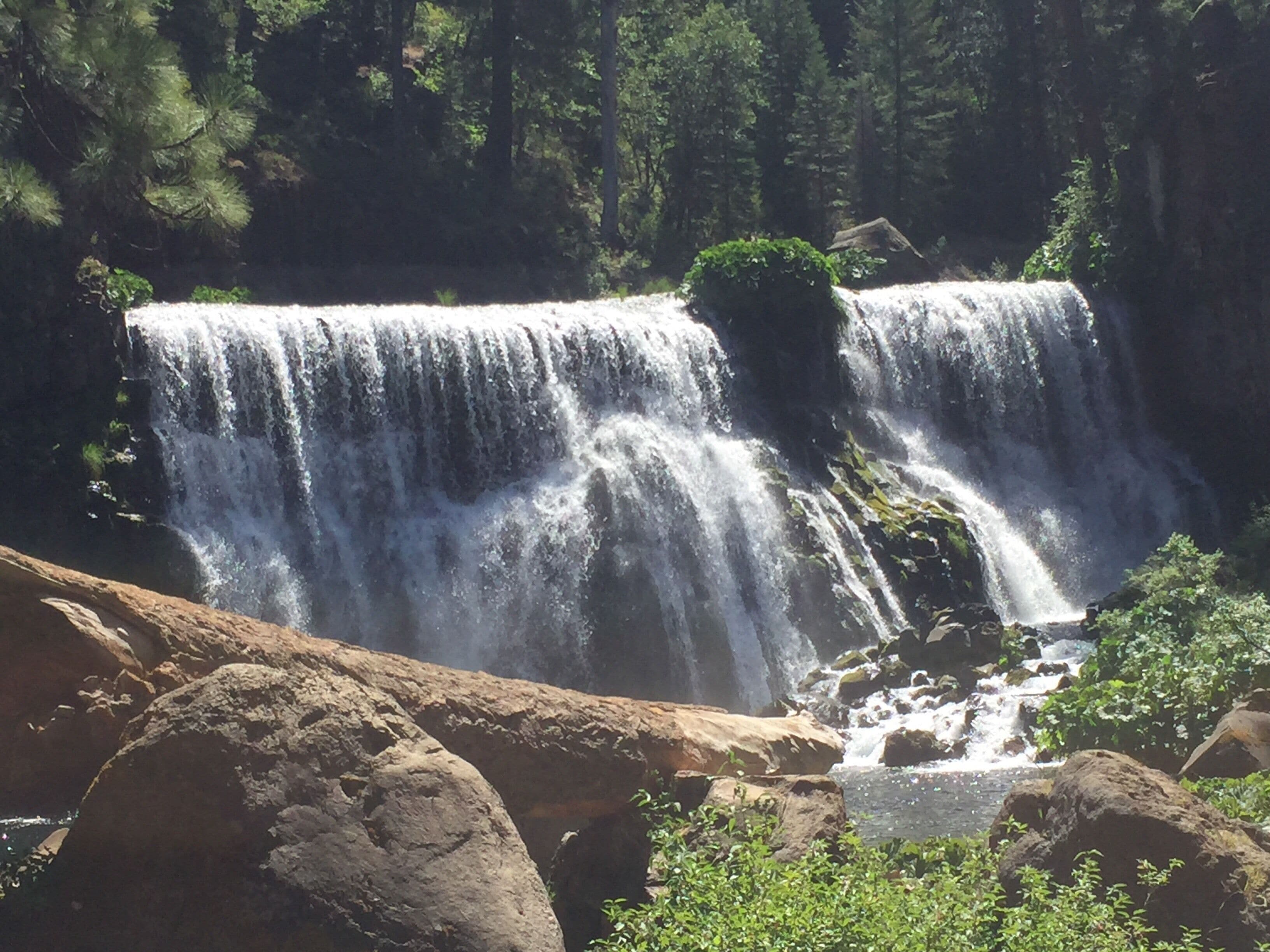 A waterfall cascading over rocks in a forested area.