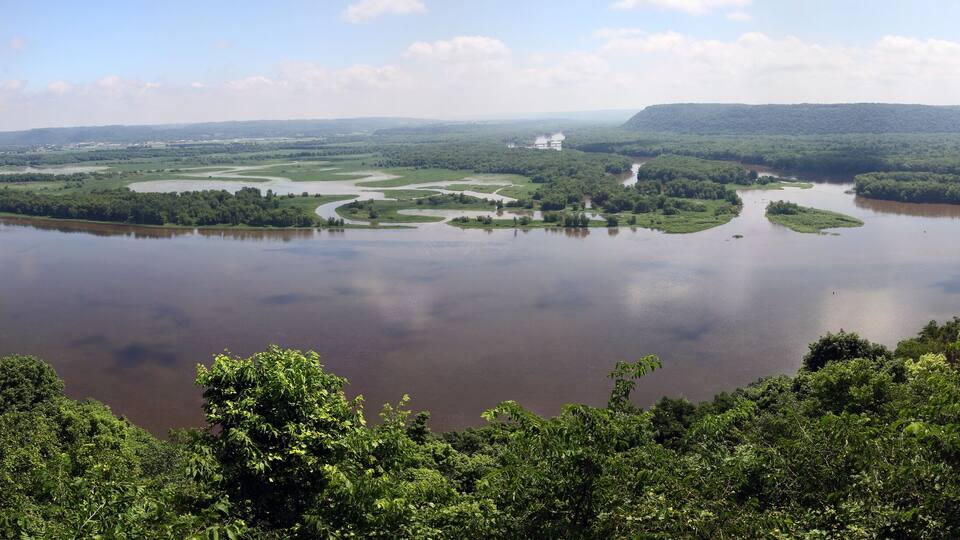 A river surrounded by dense forests and hills.