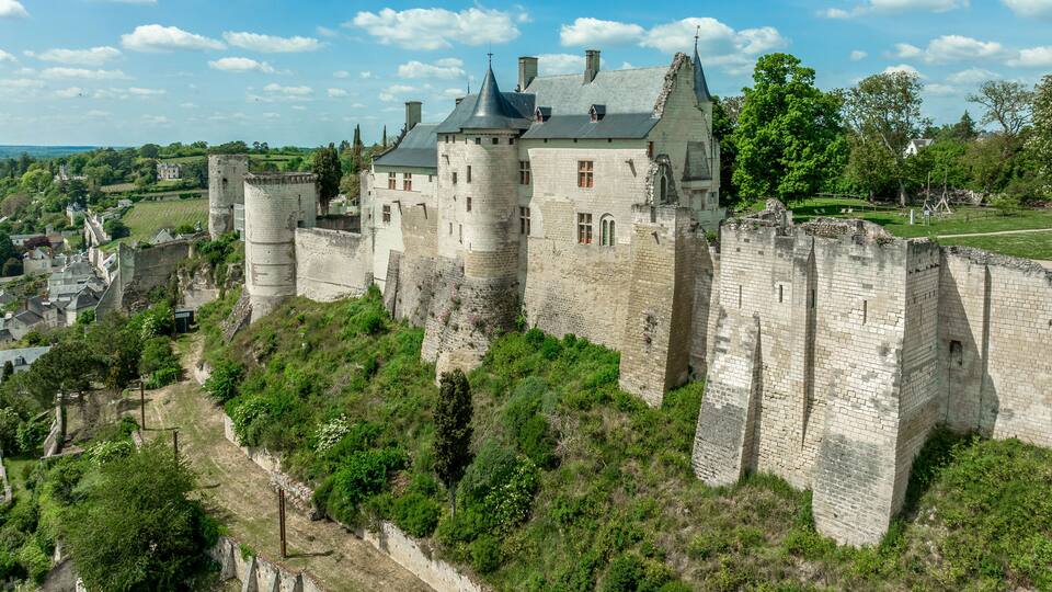 Aerial view of the royal lodgings in the middle castle of Chinon with adjoining curtain walls restored recently with blue cloudy summer sky