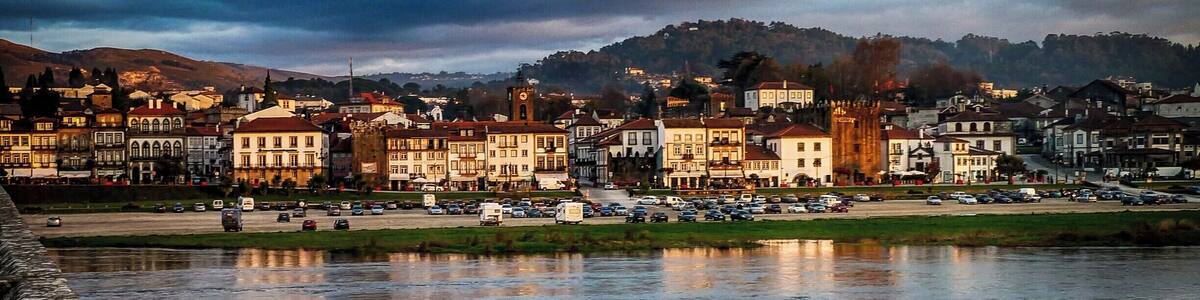 A riverside town with historic buildings and a stone wall.