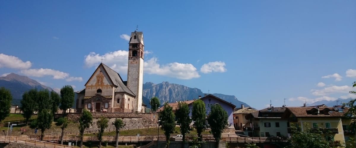 A church with a bell tower and a mountain in the background.