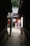 Une ruelle typique du Japon, avec ses bâtiments en bois, une lanterne rouge et un couple vêtu de costumes traditionnels.