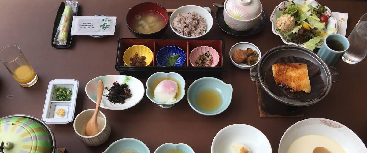 A variety of Japanese dishes including sushi, rice, and soup, arranged on a table.