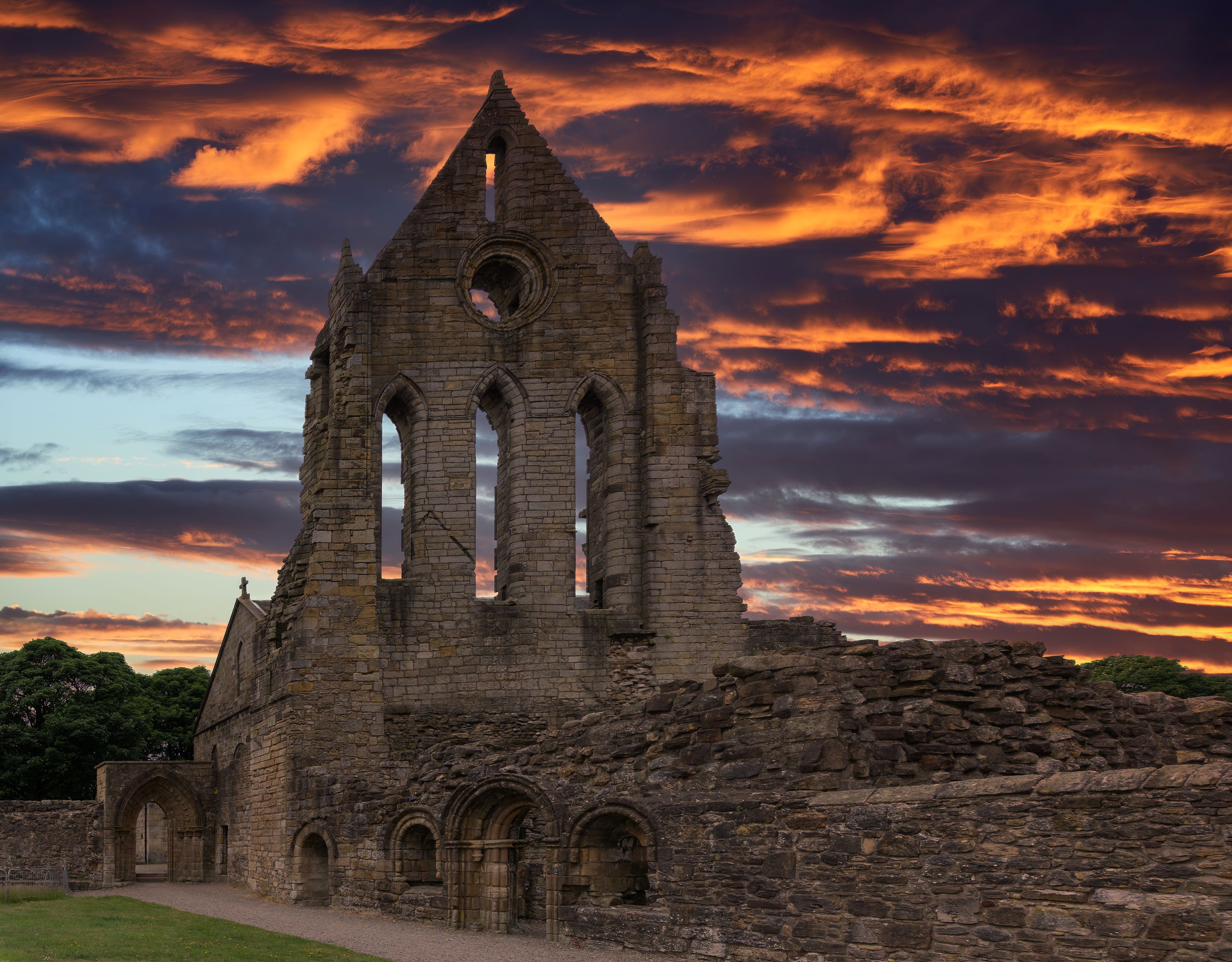 A historic stone building with a large central tower and multiple arched windows.