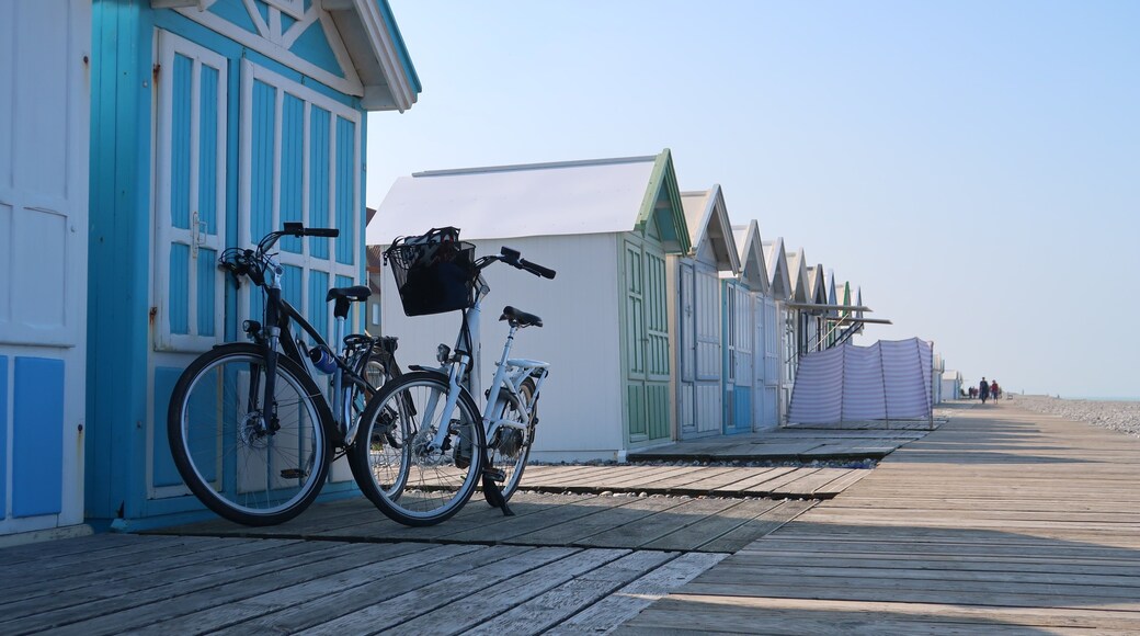 Cyclotourisme dans la baie de Somme, en Picardie / Hauts de France, deux vélos garés côte à côte devant une cabine de plage, sur les planches de la ville de Cayeux sur Mer (France)