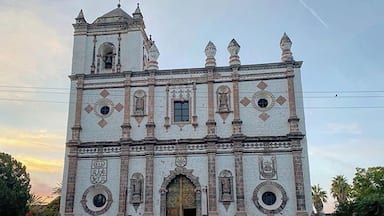 A historic church with a bell tower, arched entrance, and decorative patterns.