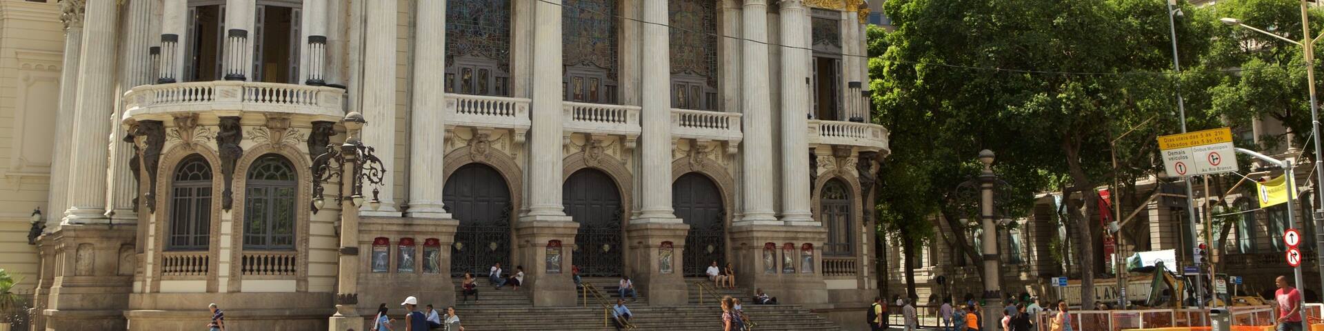 A grand opera house with ornate columns and golden statues.