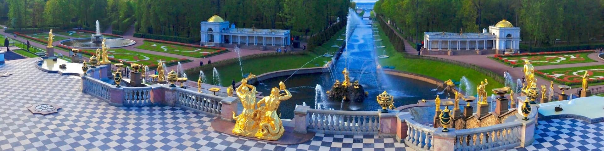 A grand garden with a central fountain, ornate statues, and a checkered floor.