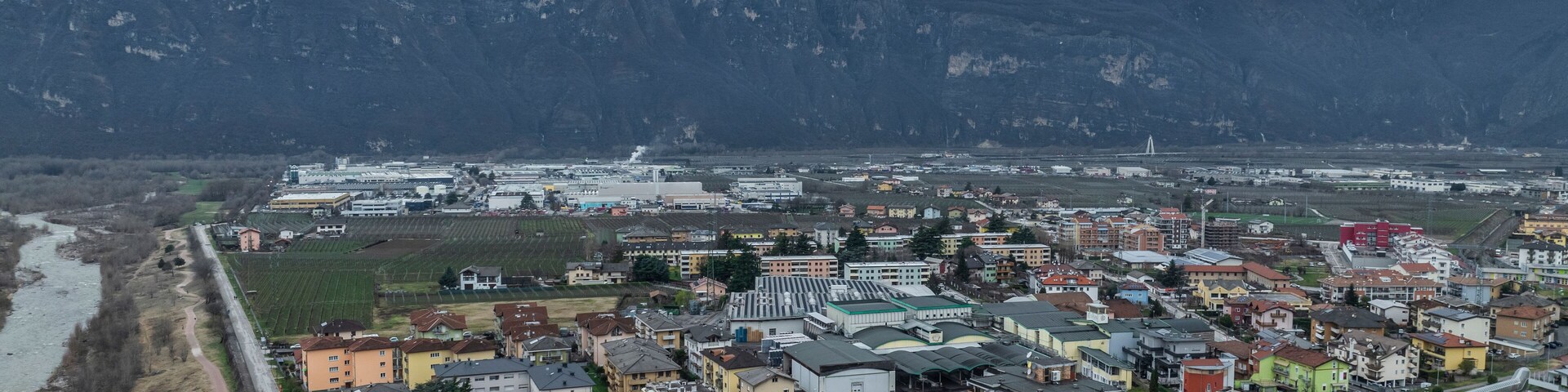 Una ciudad con un río, un puente y una montaña al fondo.