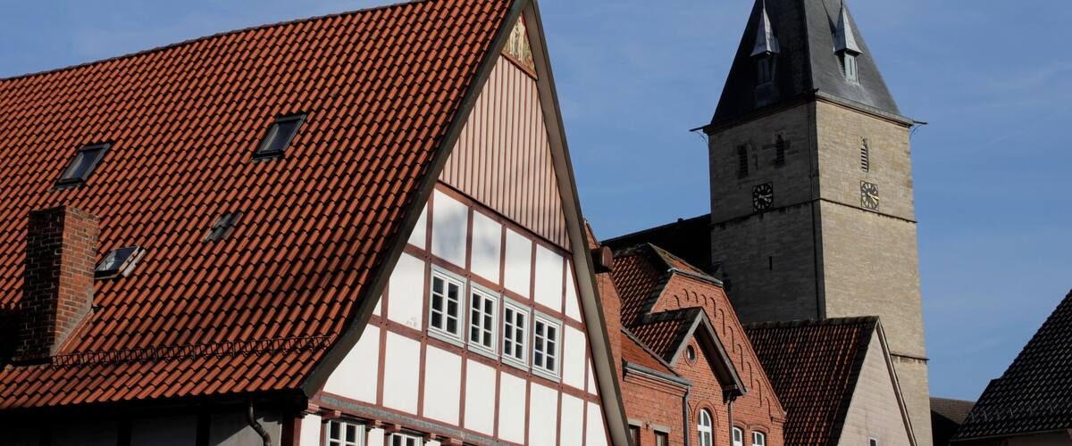 A church with a tall steeple and a red-tiled roof.