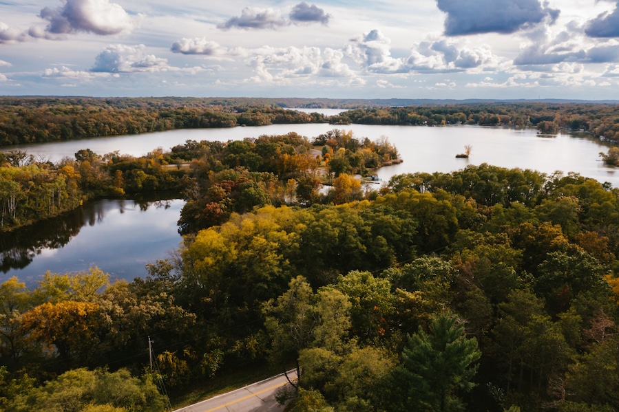 Drone photograph of gorgeous lake with forest of fall trees