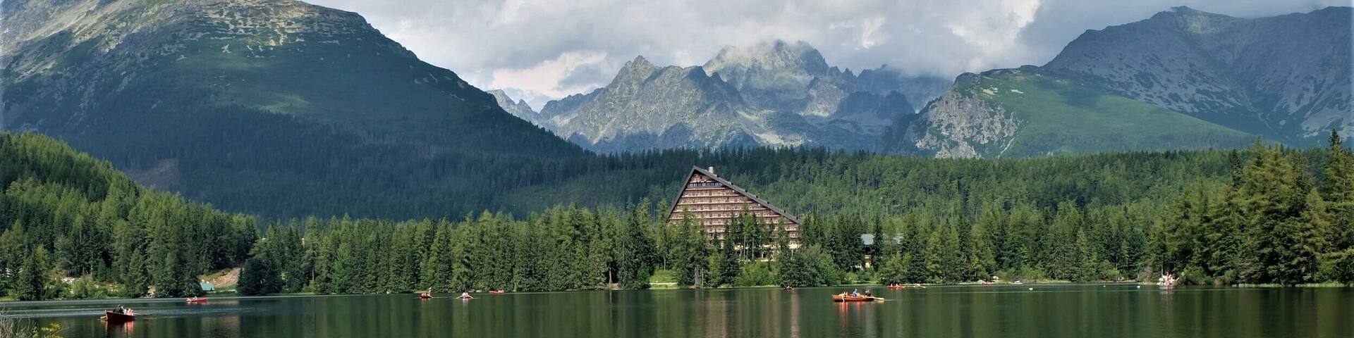 A mountain landscape with a house near a lake.