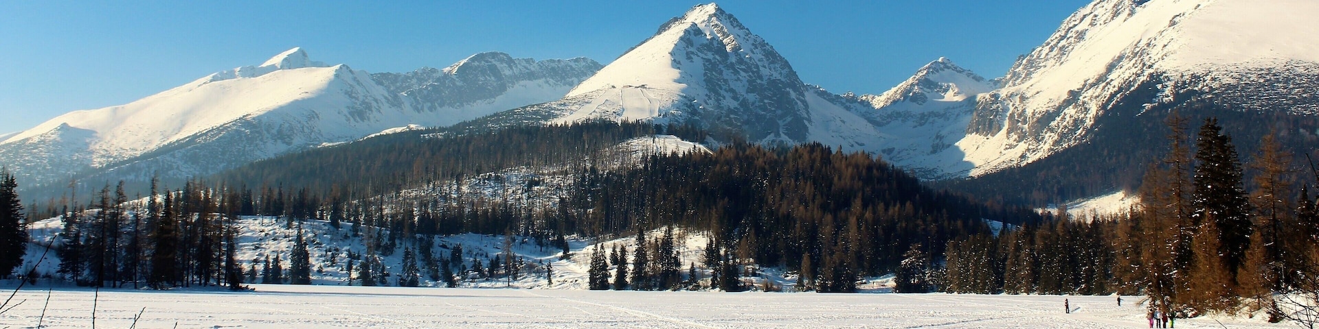 Slovakia's High Tatras Mountain! I was at a frozen glacial lake called Štrbské pleso. It's one of the most iconic landmarks in Slovakia. It is really amazing to walk on it! And to see so many people having fun! With their friends, family and classmates. It was a beautiful early March day. I had a great winter holiday this year in Slovakia :). The views were really stunning everywhere!
In my post-processing work I did edit out a construction site (or whatever it is. I never got close enough to see). So, if you visit Štrbské pleso don't be surprised it is there!
And more info about Štrbské pleso: It's the 2nd-largest glacial lake on the Slovak side of the High Tatras, Maximum depth is 20 metres (66 ft). Surface elevation is 1,346 m (4,416 ft). And it's surface remains frozen for around 155 days per year!