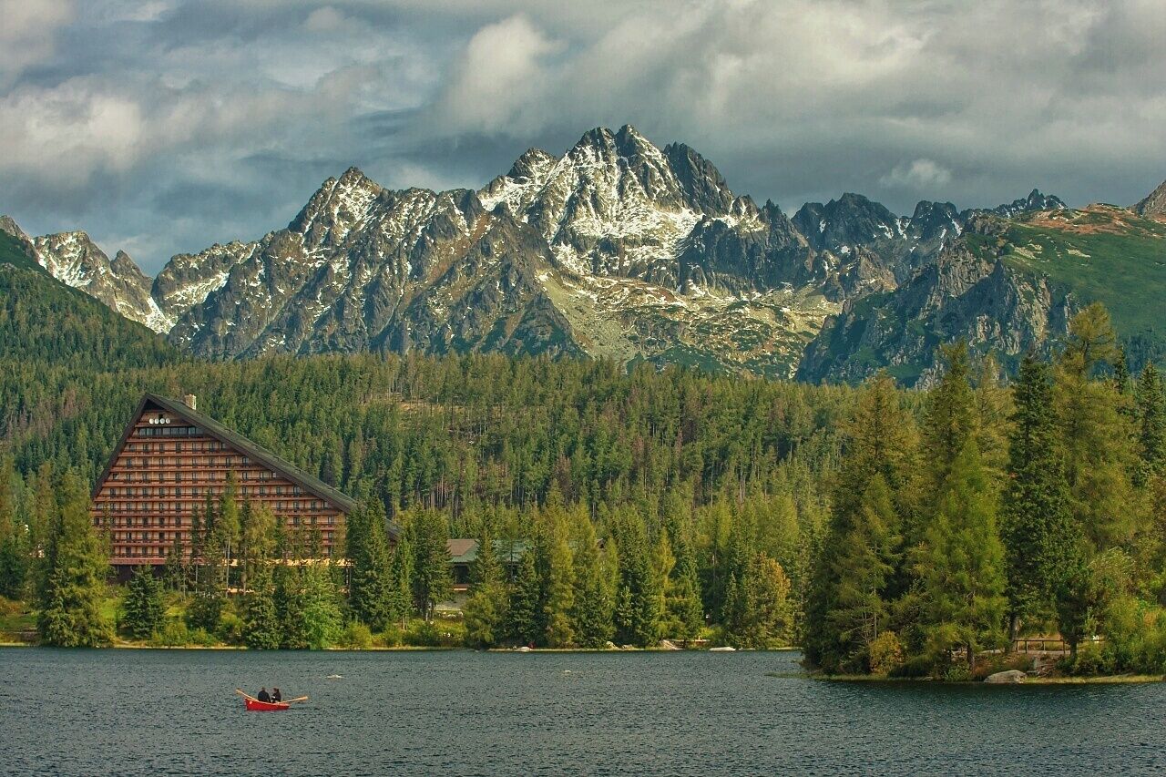 A lodge surrounded by a forest and mountains.