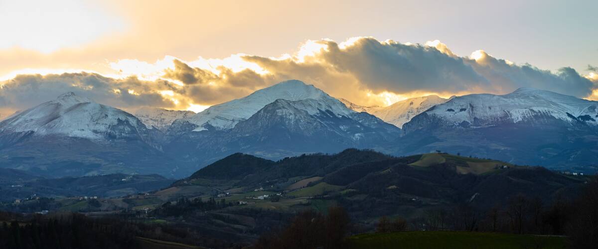 Snow-covered mountains, a valley, and a small settlement.