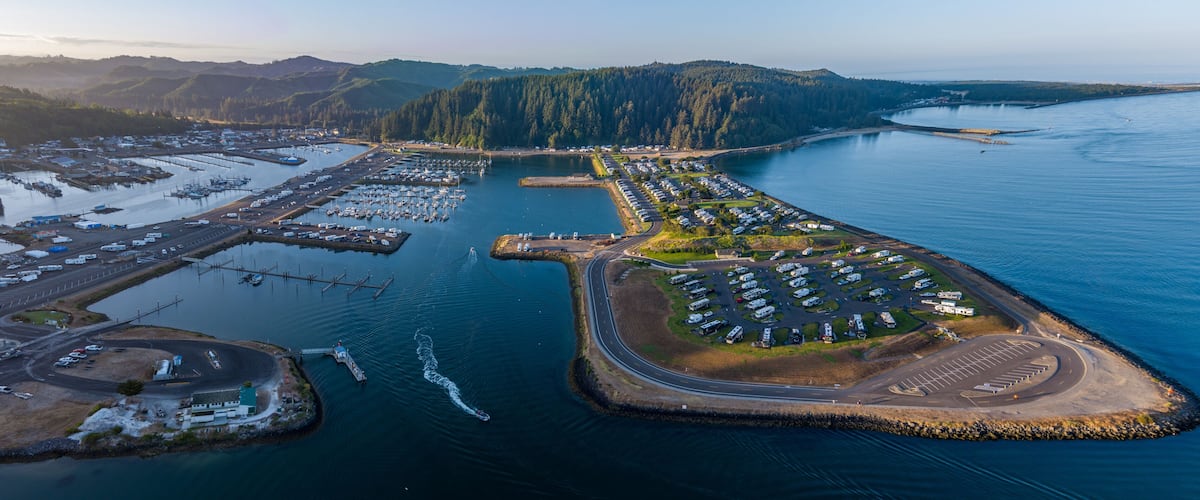 Aerial View of Winchester Bay, Oregon with the Harbor, Marina, a Rv Park and Fishing boats at sunrise.