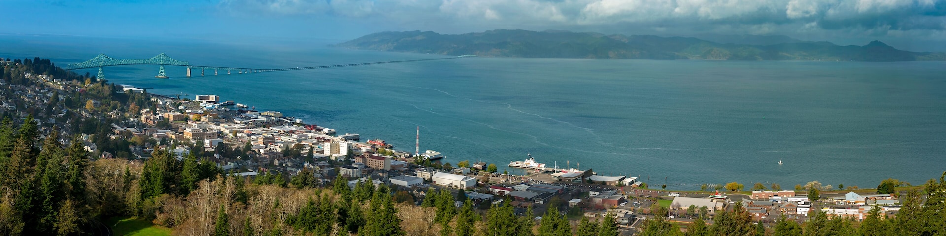 Historic Astoria, Oregon, USA. This view of the Astoria skyline is from the Astoria Column on a hill above the city featuring the beautiful Columbia River and the Astoria–Megler Bridge.