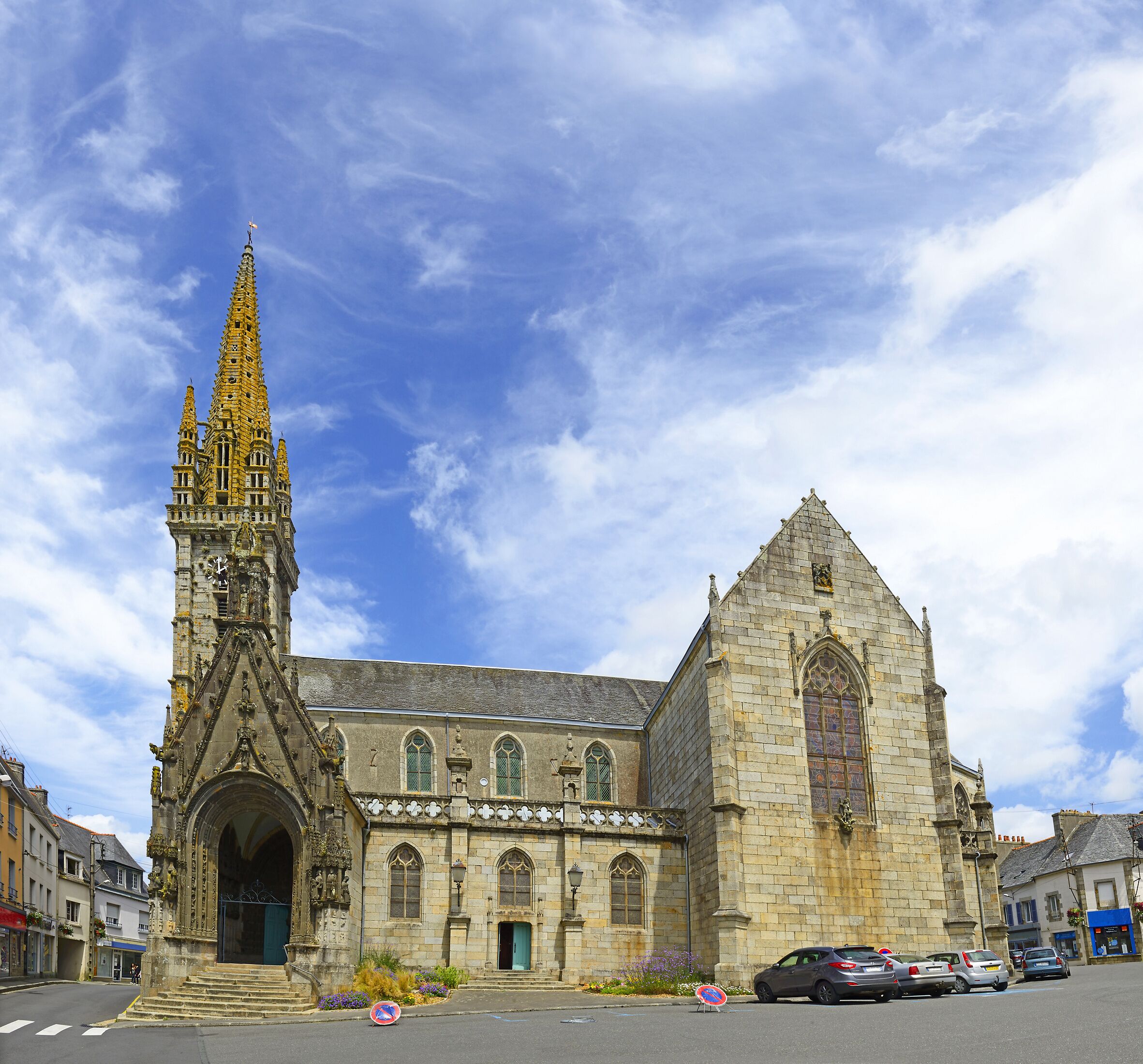 A Gothic church with a tall spire and a large rose window.