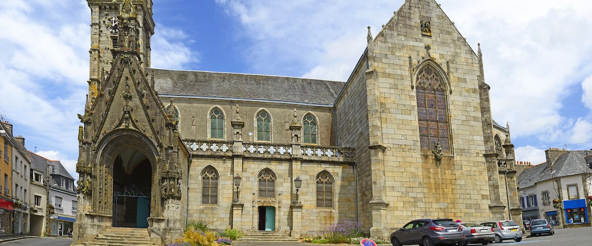A Gothic church with a tall spire and a large rose window.