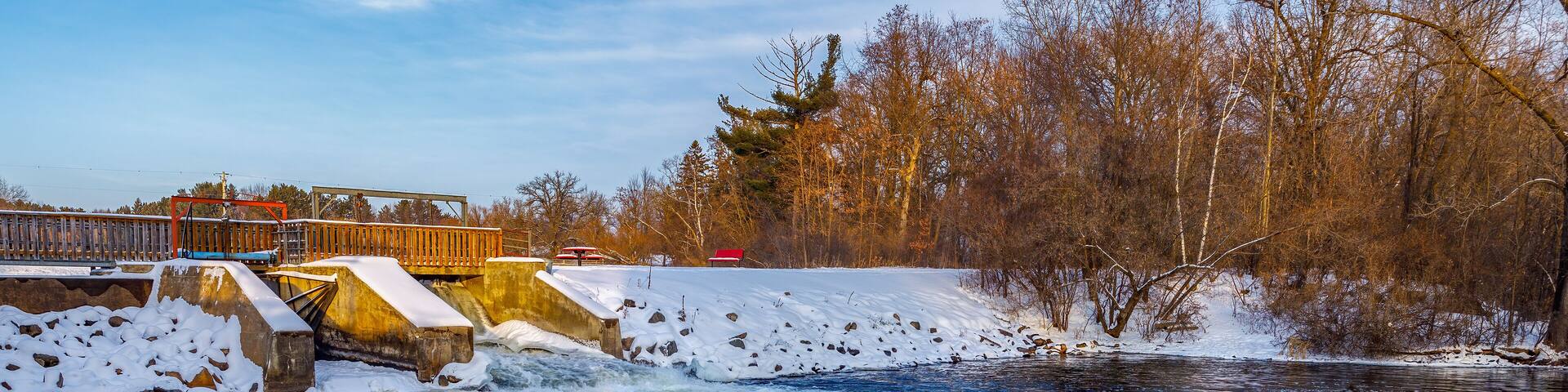 Amery Dam on the Apple River in Amery Wisconsin during winter with snow.