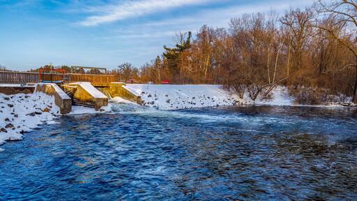 Amery Dam on the Apple River in Amery Wisconsin during winter with snow.