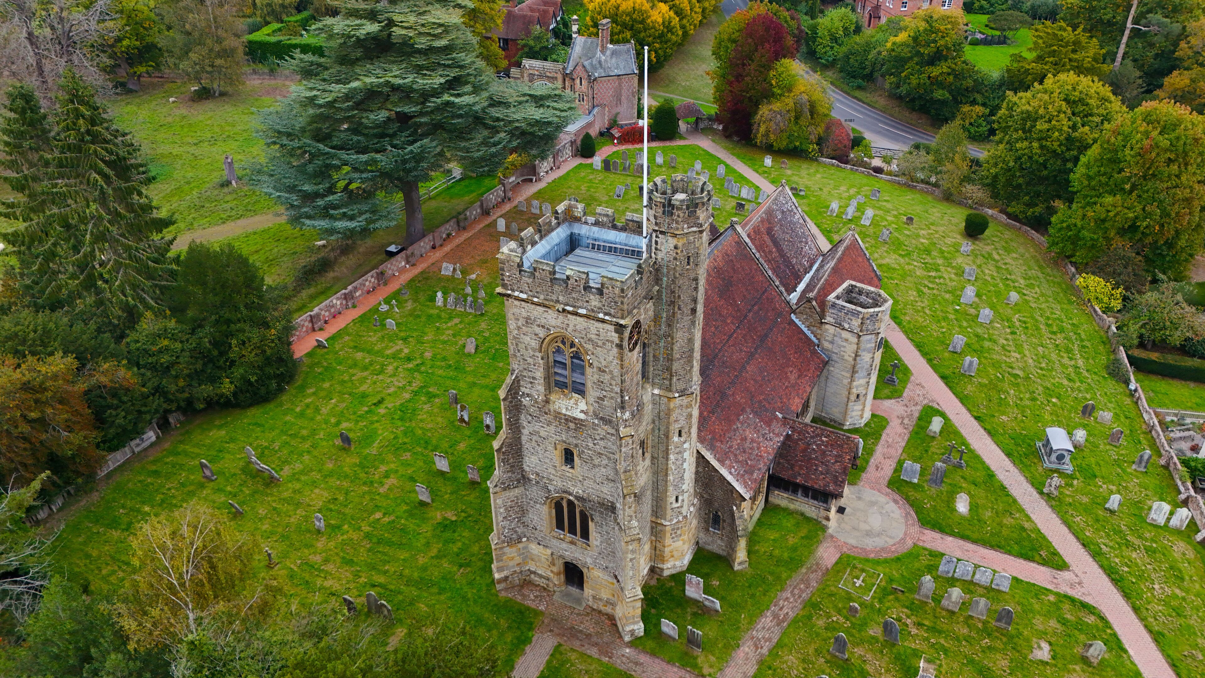 A historic church with a bell tower, surrounded by a cemetery.
