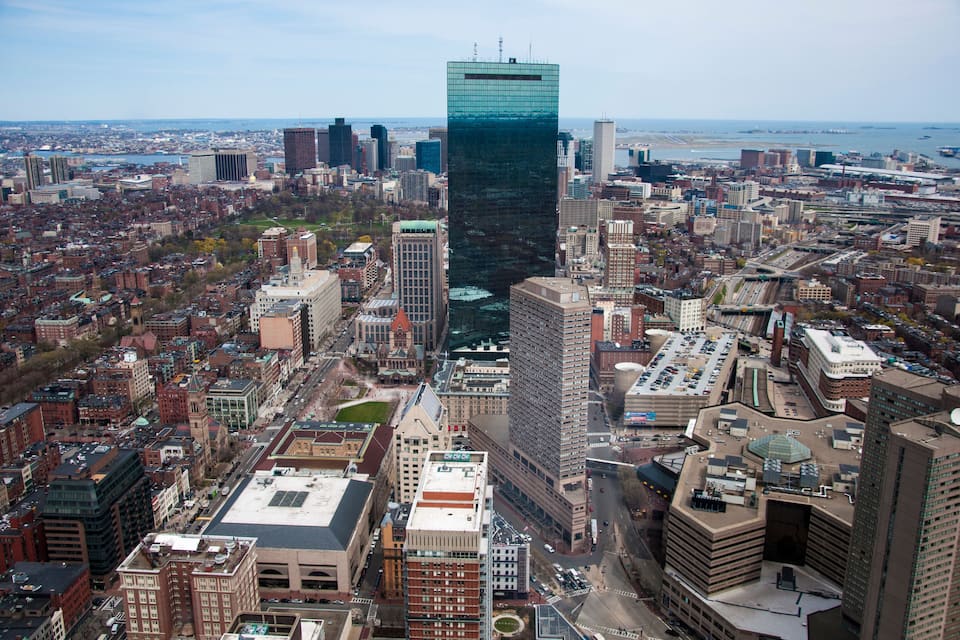 A cityscape with a prominent modern skyscraper, historic buildings, and a river.