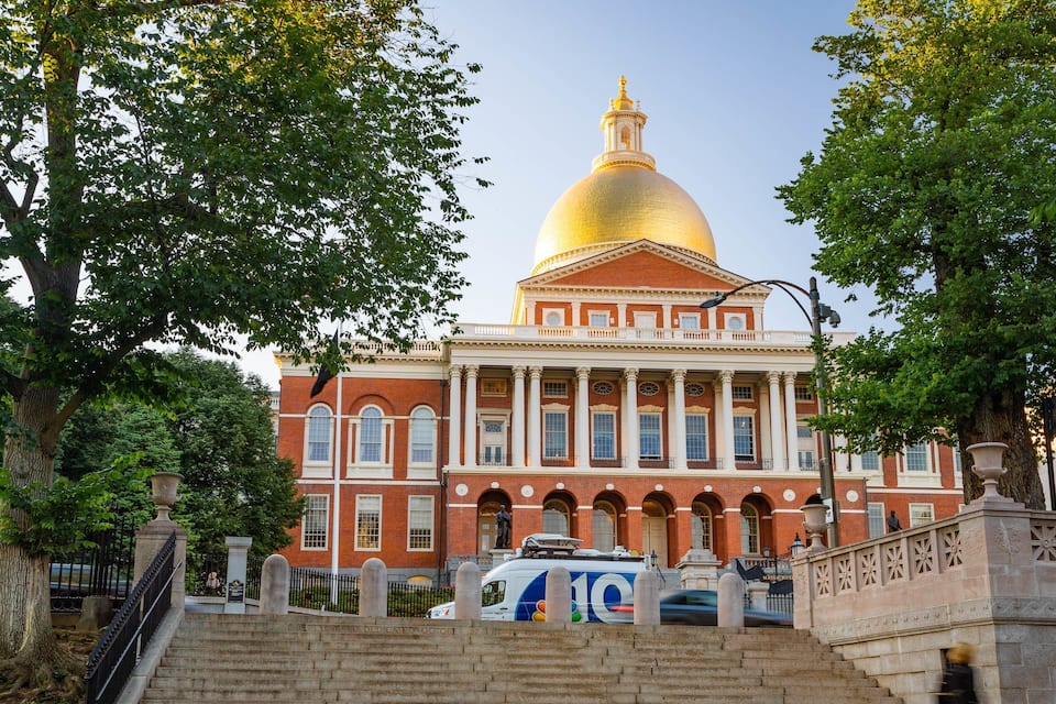 A large building with a golden dome, red brick walls, and white columns.
