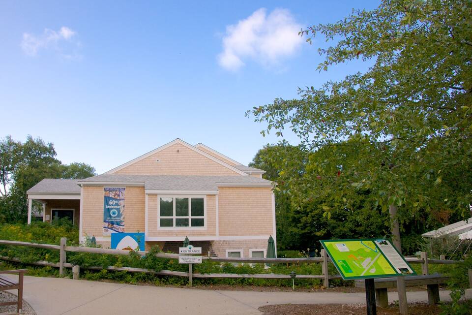 A building with a '60th Anniversary' banner, a sign for 'Wildflower Gardens', and a map sign.