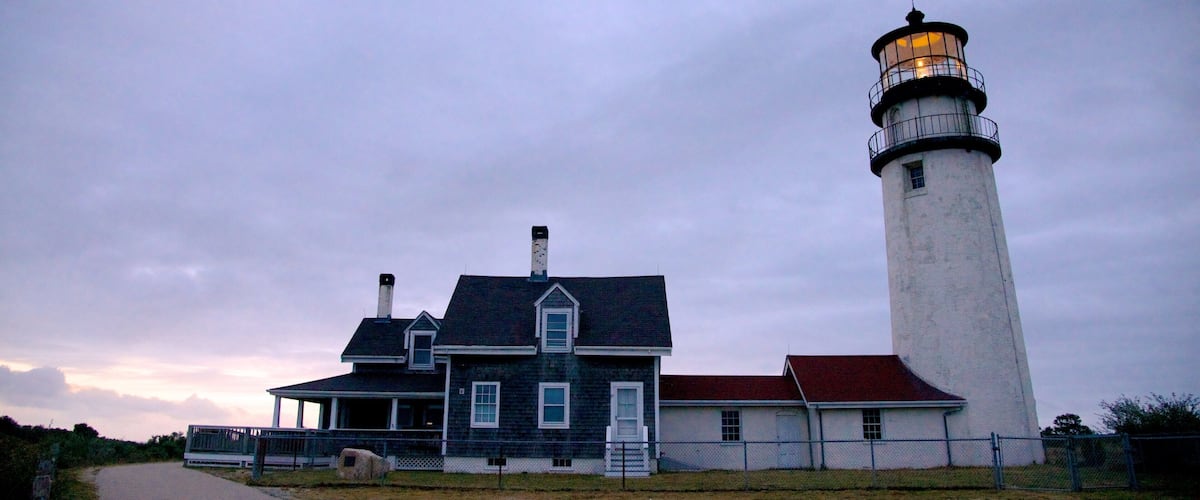 A lighthouse and a house by the coast.