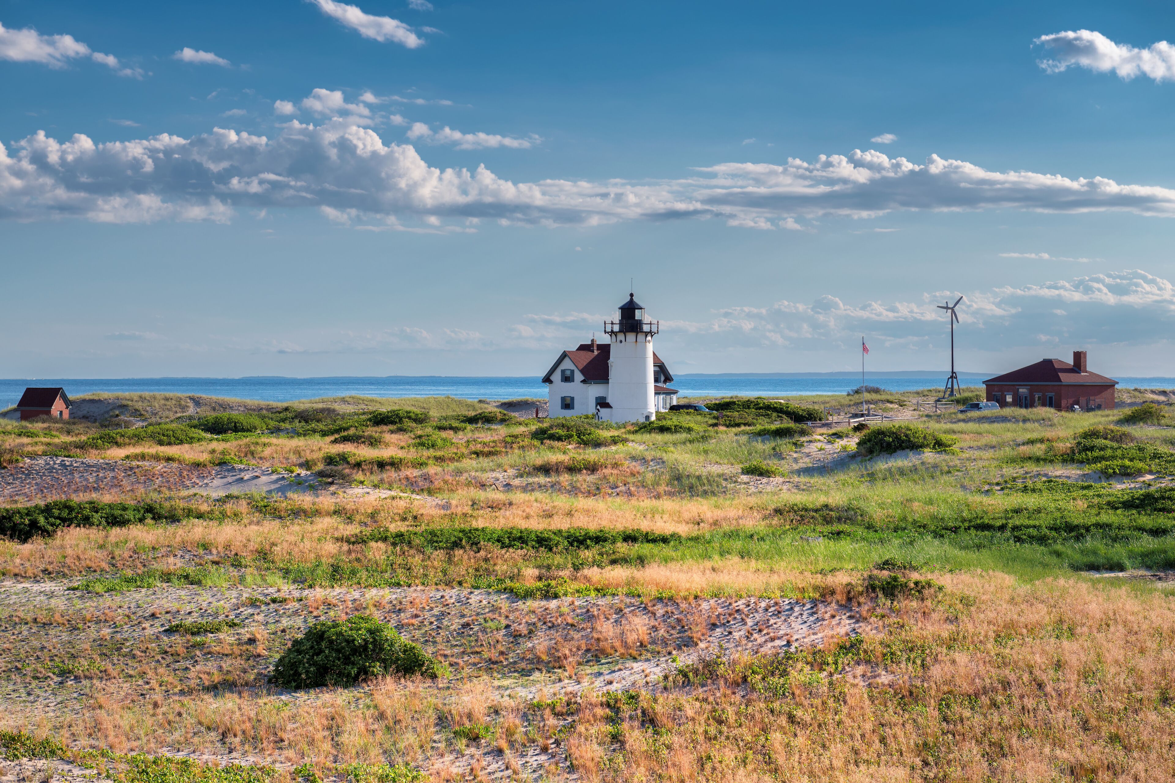 Sand dunes on the beach and Race Point Light Lighthouse in Cape Cod, New England,  Massachusetts, USA.