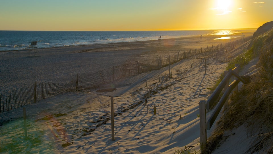A beach with a wooden fence and a chair.