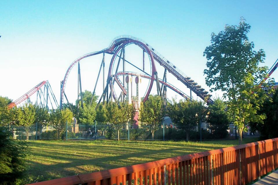 A roller coaster at an amusement park with a clear sky.