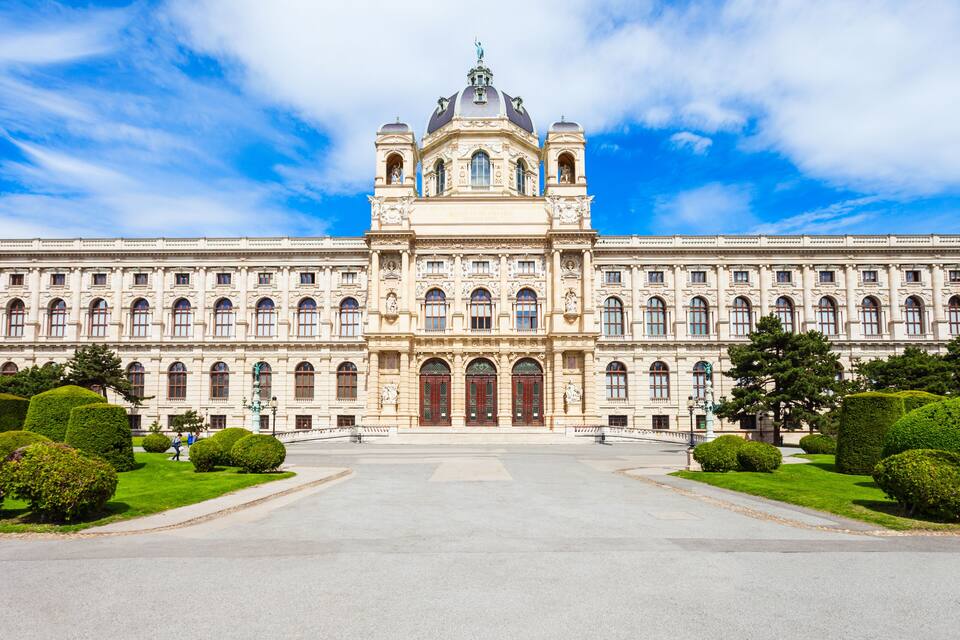 Ein prächtiges, neoklassizistisches Gebäude mit symmetrischer Architektur, großen Zwerchbalkentüren und einer markanten Kuppel.