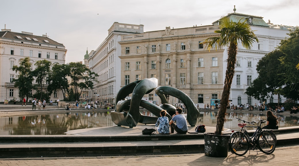 Karlsplatz showing a fountain and a sunset as well as a couple