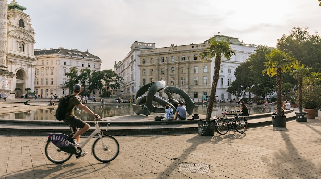 Karlsplatz featuring a sunset, a fountain and cycling