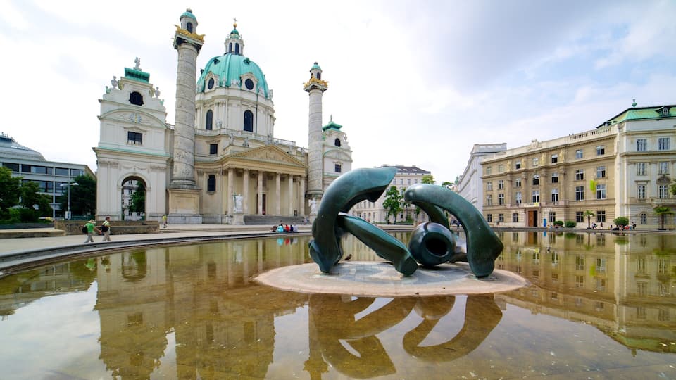 Karlskirche toont een standbeeld of beeldhouwwerk, een vijver en een kerk of kathedraal