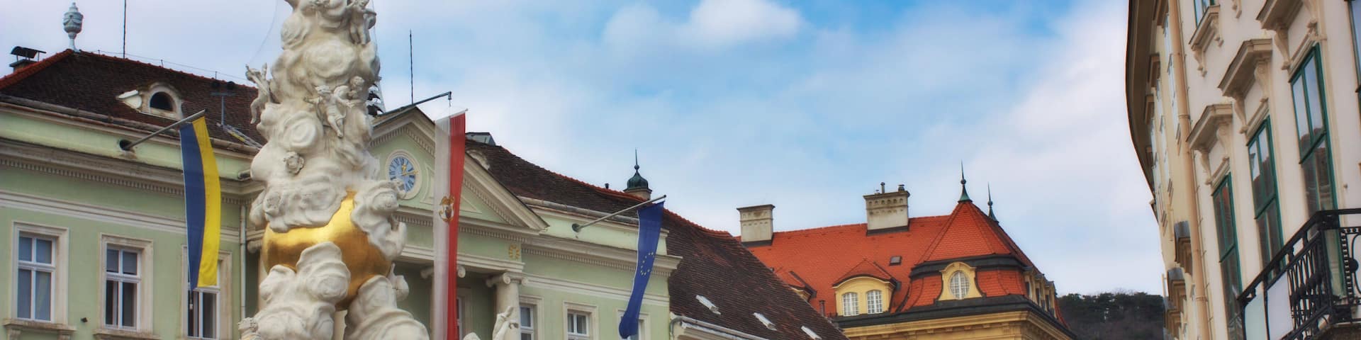 Plague column and the main street in a small town of Baden, Austria